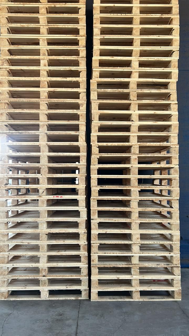 Pasillo de bodega con pallets de madera apilados